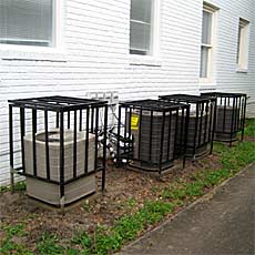 A multi unit building with four chill safe cages enclosing four condensors.